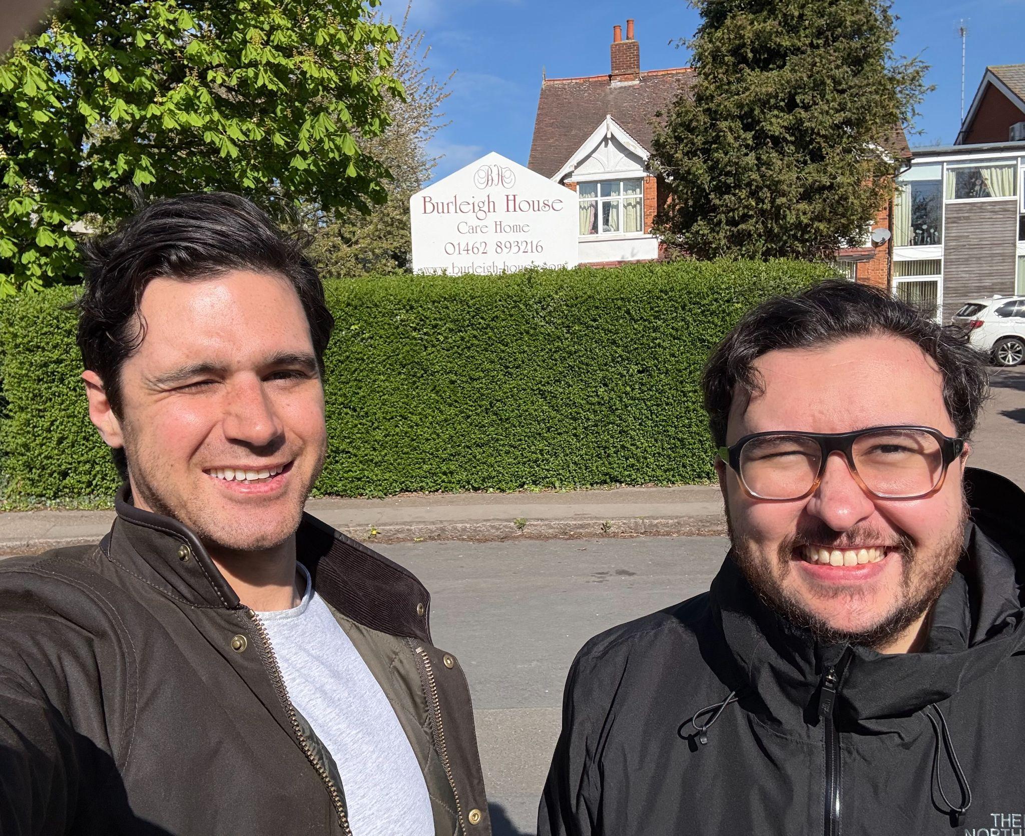 Artur and Geoff outside Burleigh House on the day of the pilot launch, with the care home sign in view