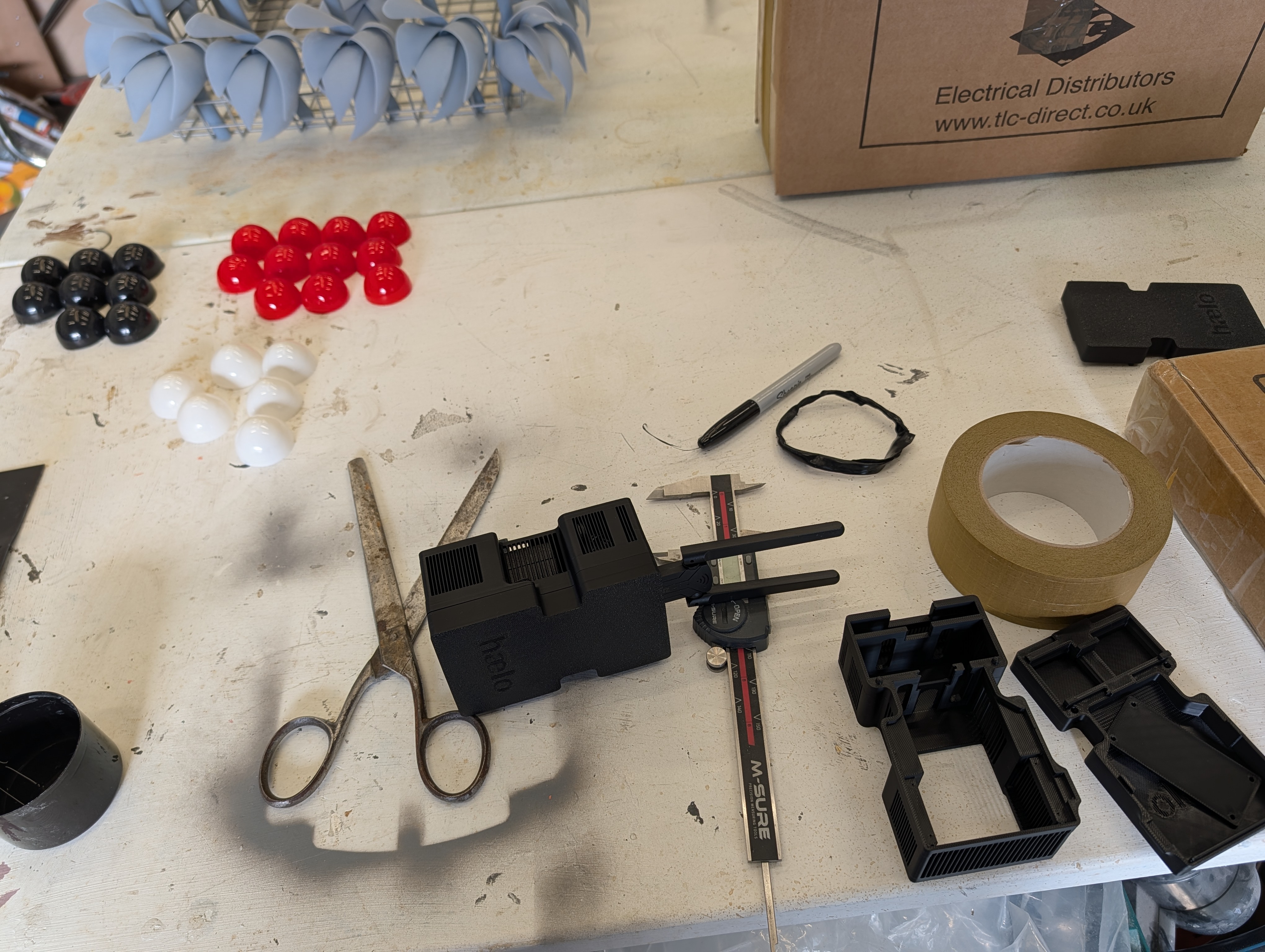 Hub enclosures in various stages of assembly, with calipers on the workbench
